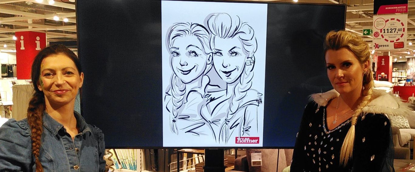 Zwei Frauen vor einem Bildschirm, worauf eine digitale Zeichnung von Ihnen zu sehen ist